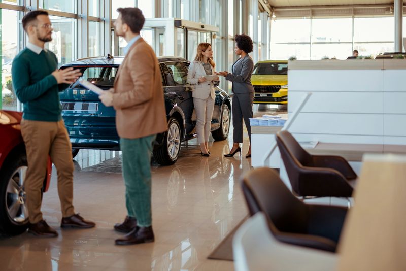 Group of Buyers and Sellers Talking in a Car Showroom