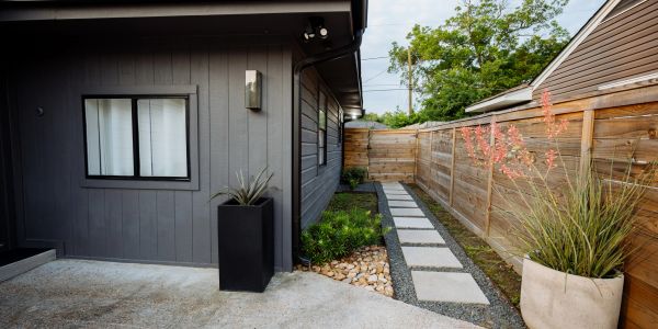 Modern house exterior with concrete pathway and plants.