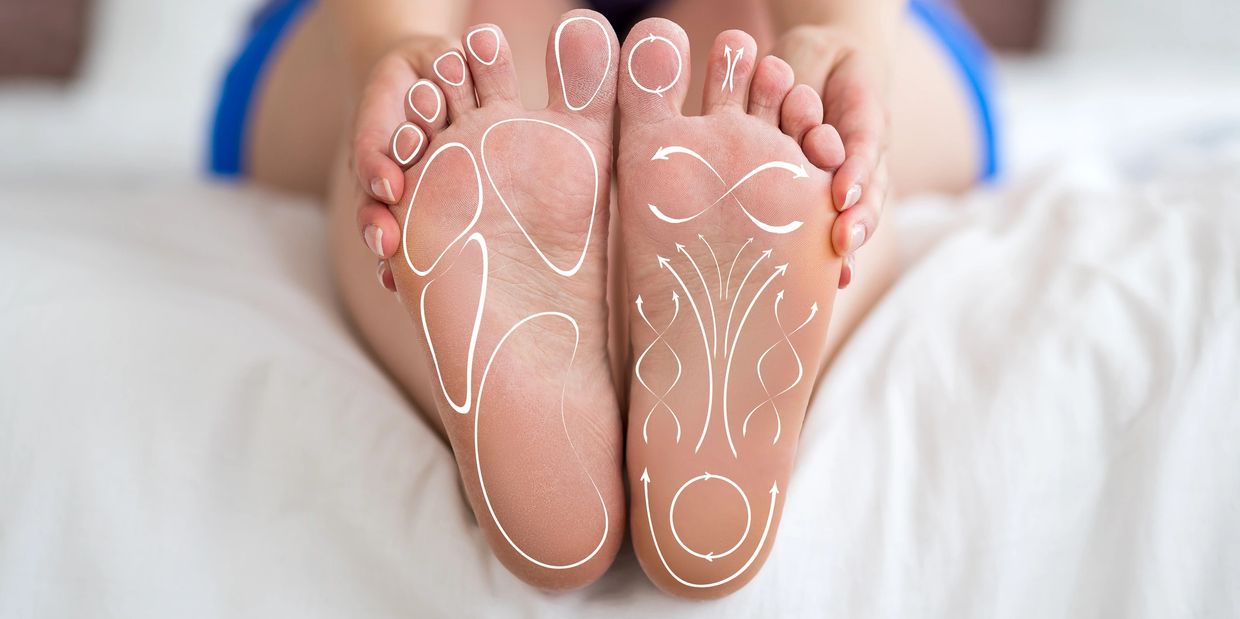 Feet with reflexology zones and arrows for massage.