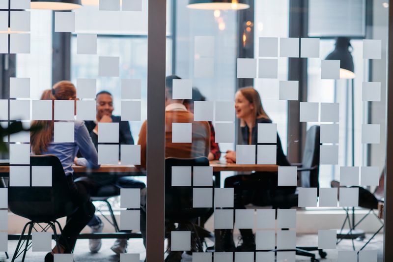 A team of business professionals engage in lively discussions and exchange strategic ideas, showcasing collaboration and innovation at the heart of modern corporate culture.