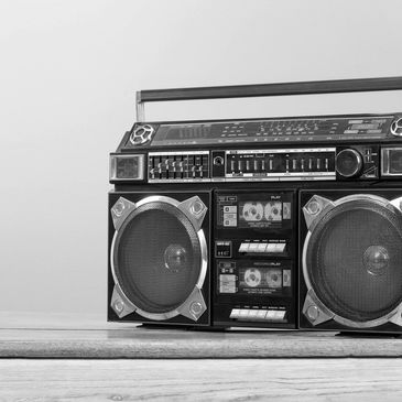 Vintage black boombox with dual cassette players on wooden table.