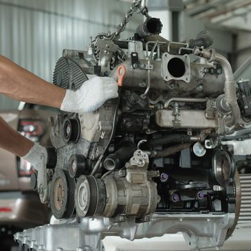 Mechanic working on a car engine in a garage.