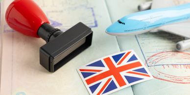 A British flag, a red stamp, and a blue toy airplane on travel documents.