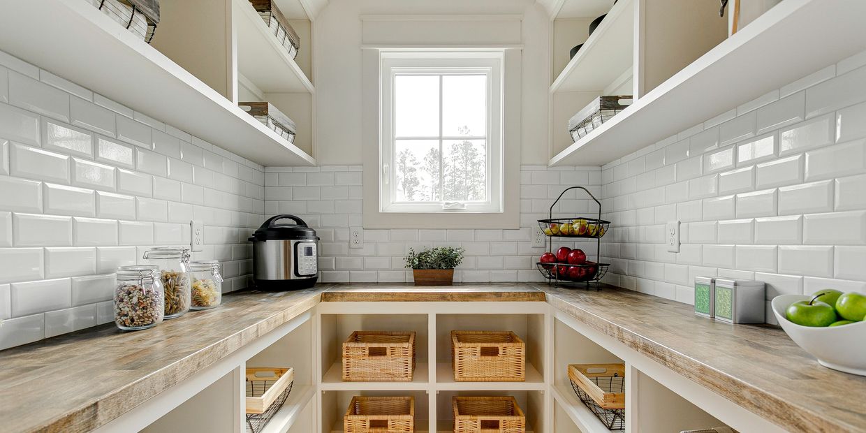 Bright, organized pantry with wooden countertops and wicker baskets.