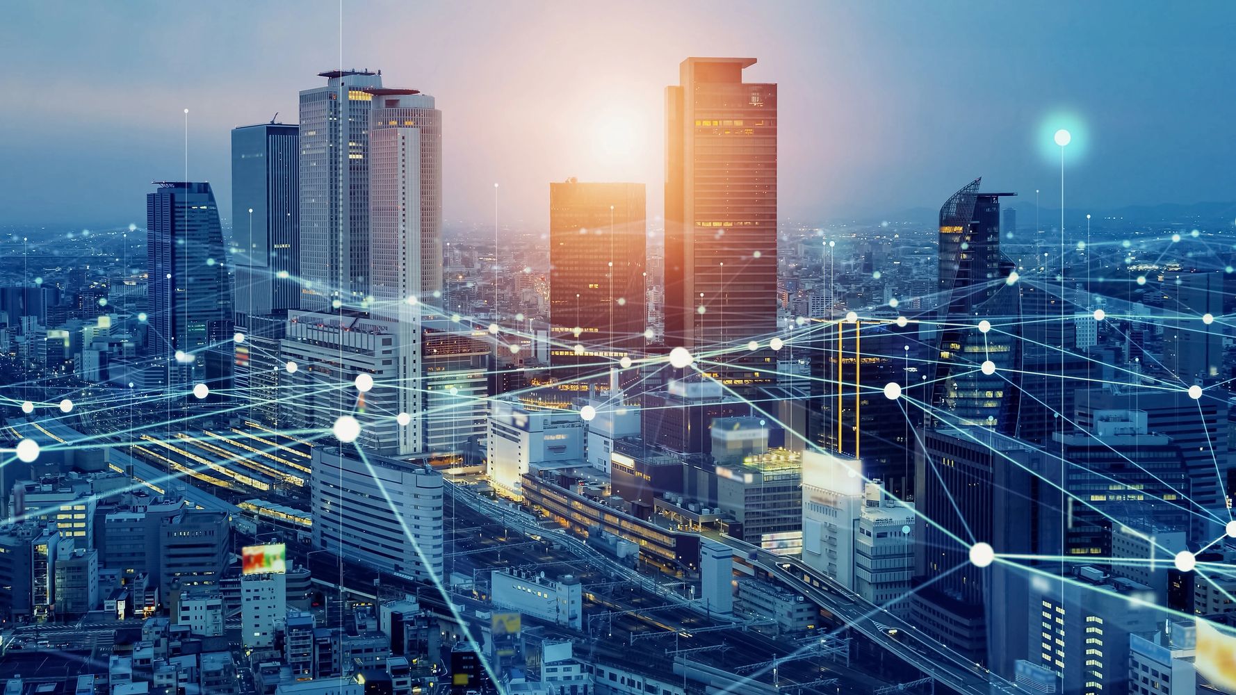 Cityscape with digital network connections overlay at sunset.
