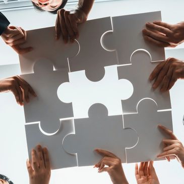 Teamwork putting together a puzzle at work.