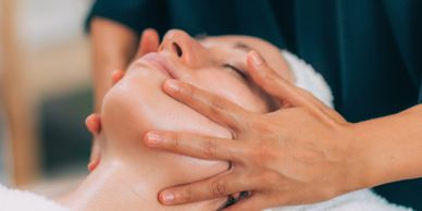 Person receiving a relaxing facial massage at a spa.