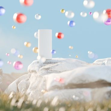 A white rectangular object stands on a rock with colorful bubbles floating around.