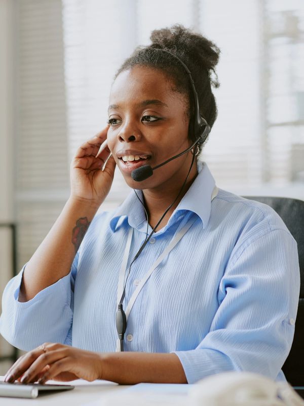 Smiling agent assisting a customer in a bright office.