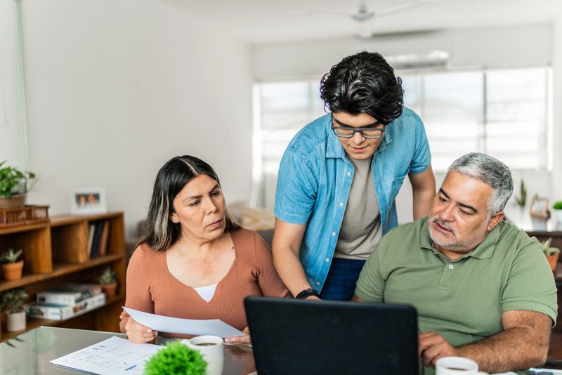Family talking and doing home finances on laptop at home
