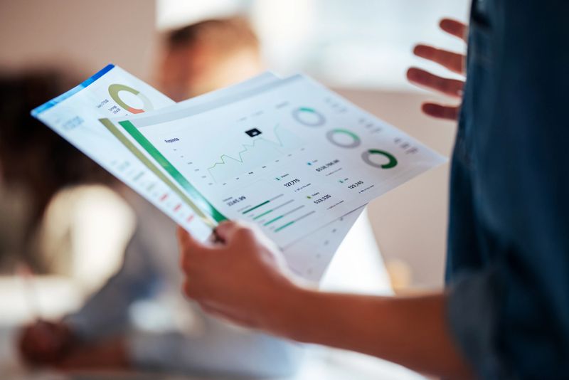 Detailed close-up of business reports, charts, and data analysis in a professional office setting, highlighting teamwork and corporate strategy.