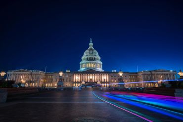 Night view of the illuminated US Capitol building.