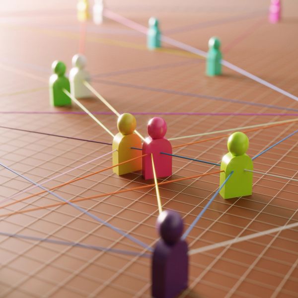 Colorful figurines connected by strings on a grid, symbolizing a network.