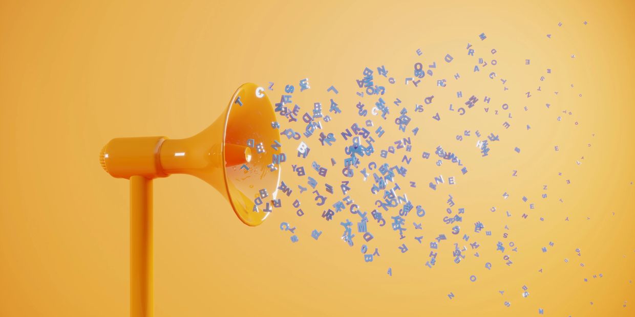 An orange megaphone spewing out blue letters.