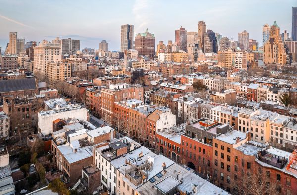 A cityscape with mixed old and new buildings at sunset.