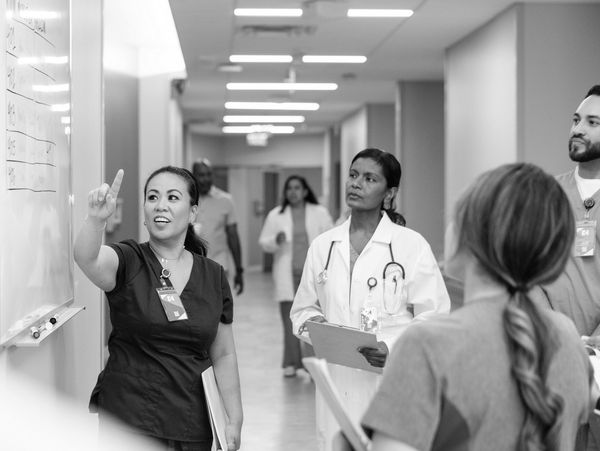 Diverse healthcare professionals collaborating in a clinical corridor within an inclusive workplace.