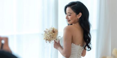 Bride in a white dress holding dried flower bouquet.