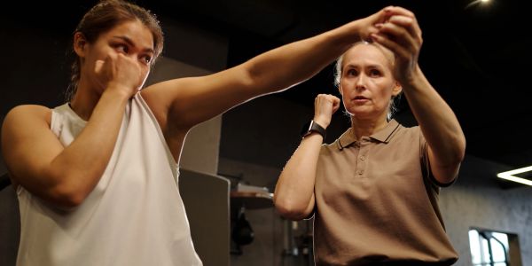 Two women practicing self-defense together.