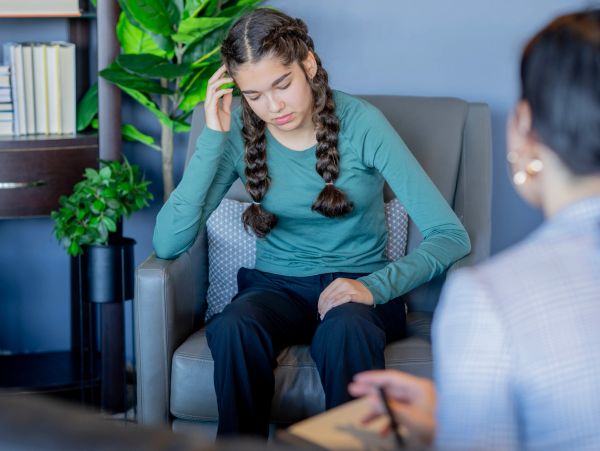 Teen girl looking stressed during therapy session.