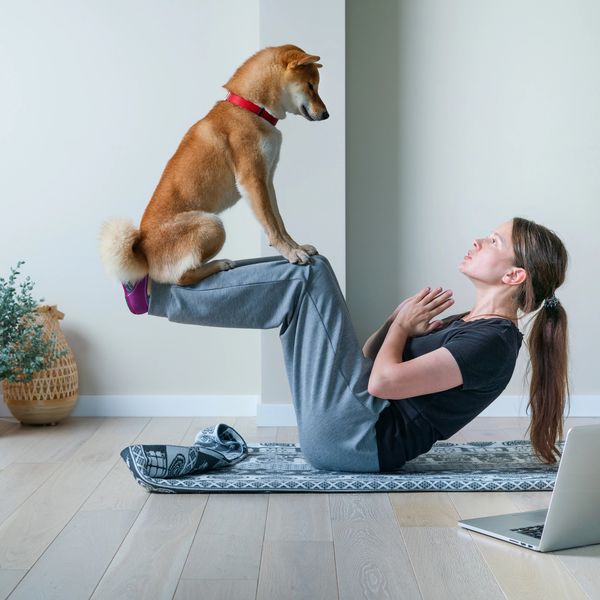 Lady doing yoga with a dog 
doga
dog yoga