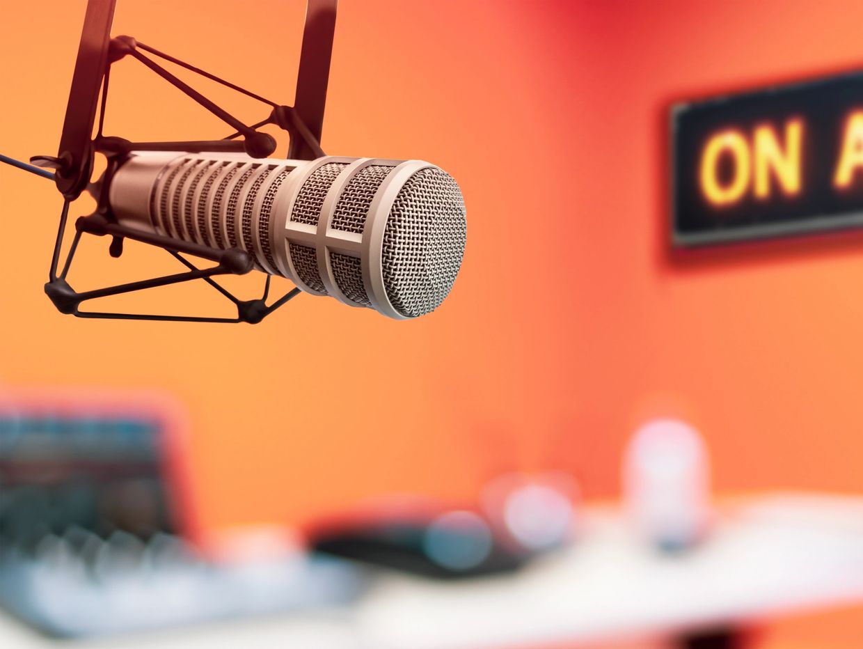 Professional microphone in a radio studio with an 'On Air' sign.