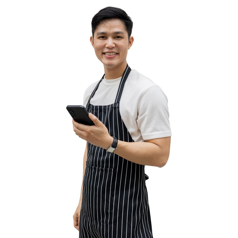 close up young asian businessman owner looking while smile during hold smartphone and stand  isolated on white background for SME business and png with clipping path design concept