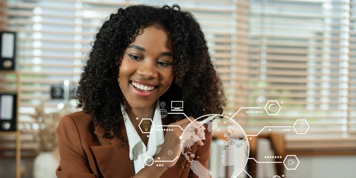 Black woman smiling in an office looking at a computer screen