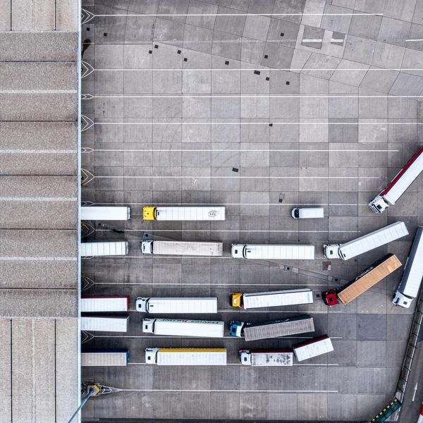 Aerial view of trucks lined up at a large industrial loading dock.