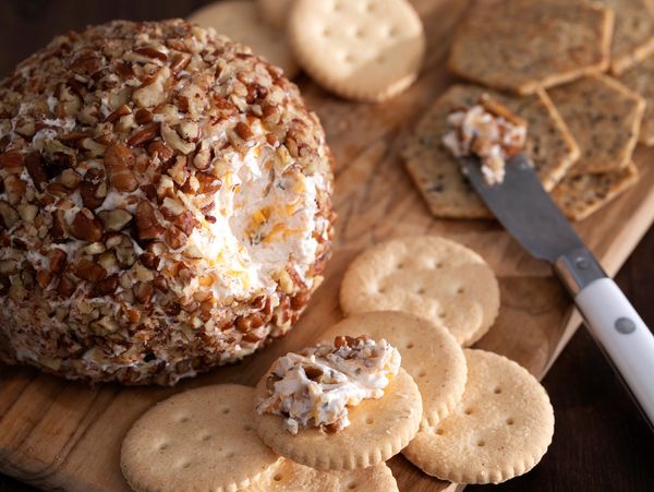Cheese ball coated with nuts and crackers.