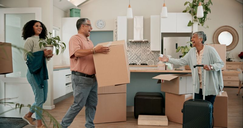 Senior parents, woman and boxes in new home for help, support or luggage with family at property. People, mother and dad with moving, suitcase or excited for investment in real estate for retirement