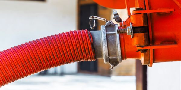 Close-up of a red industrial hose connected to equipment.