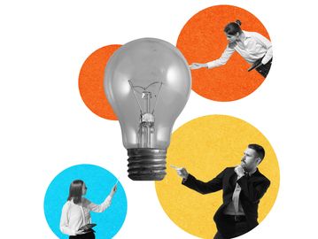 Black and white businesspeople pointing at a large light bulb with colorful circles behind them.