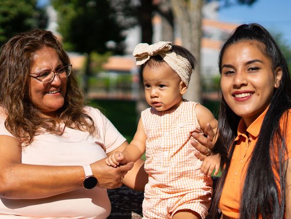 Three generations of women outdoors on a sunny day.