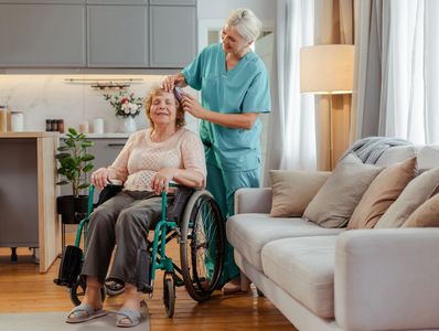 A senior woman in a wheelchair receiving personal care & hygiene support from a caregiver in a San A