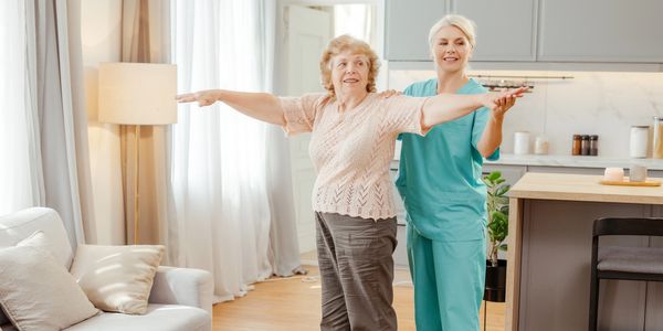 Senior an caregier exercise in living room