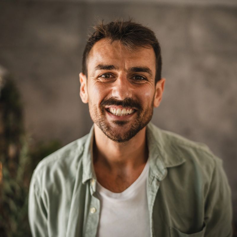 close up portrait of adult man stand and smile at home