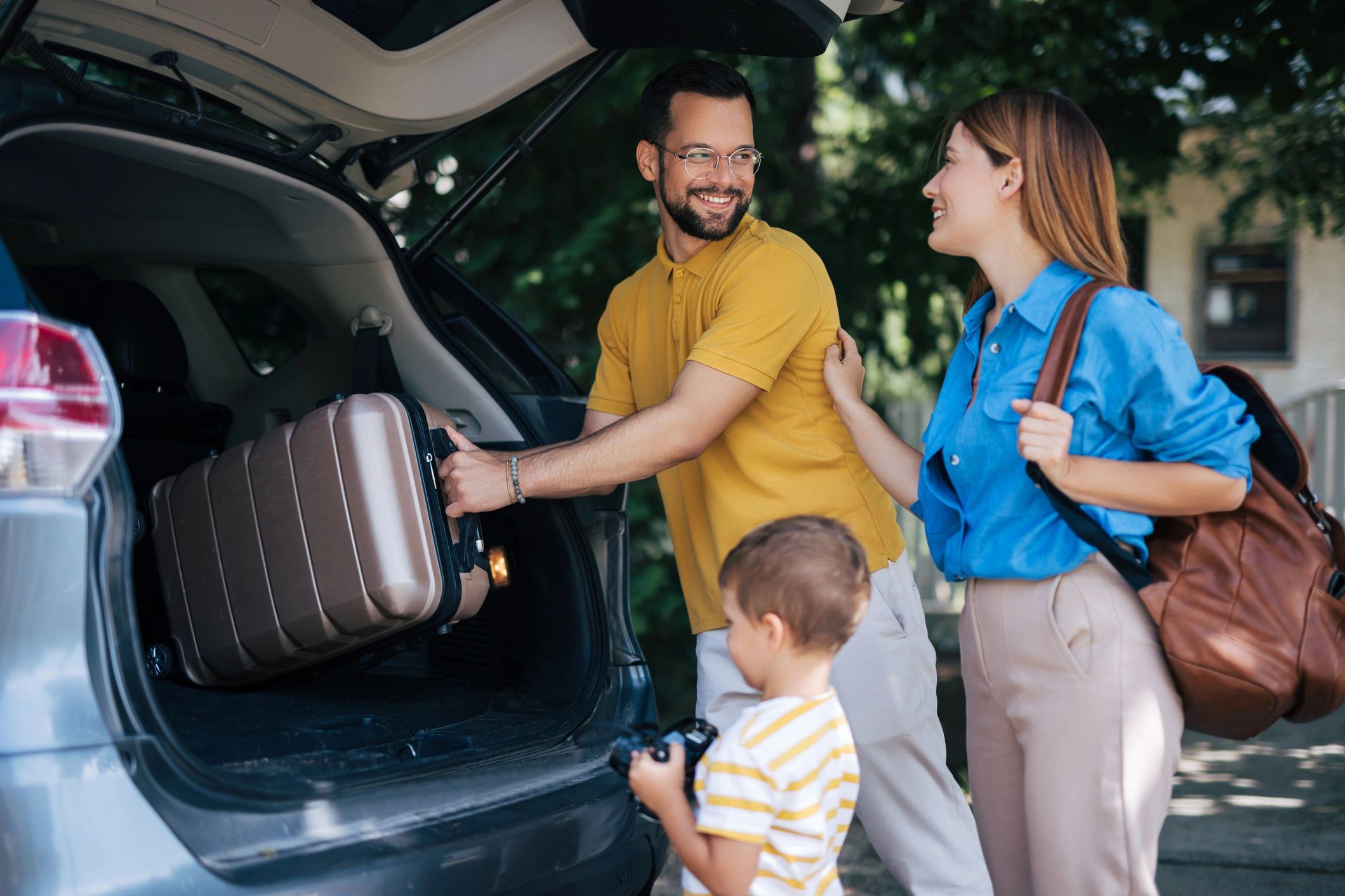 Family loading luggage into the back of an SUV