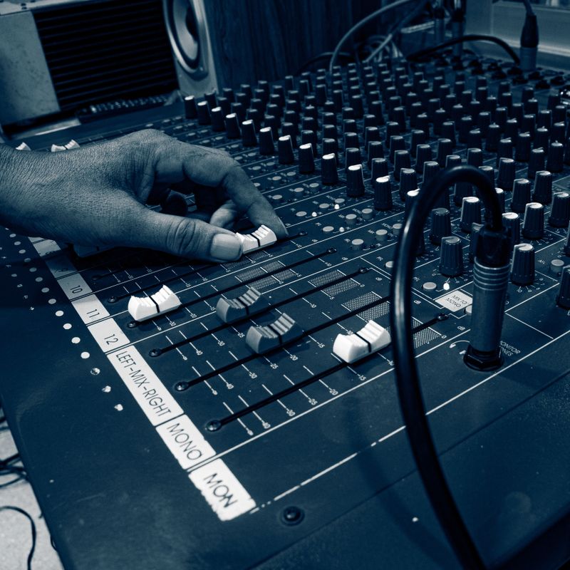 Hands of professional circuit board and audio equipment operator with audio mixer. Behind the scenes sound control is used for events, music, conferences.