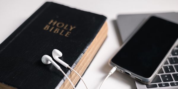 Bible and smart phone on top of computer keyboard