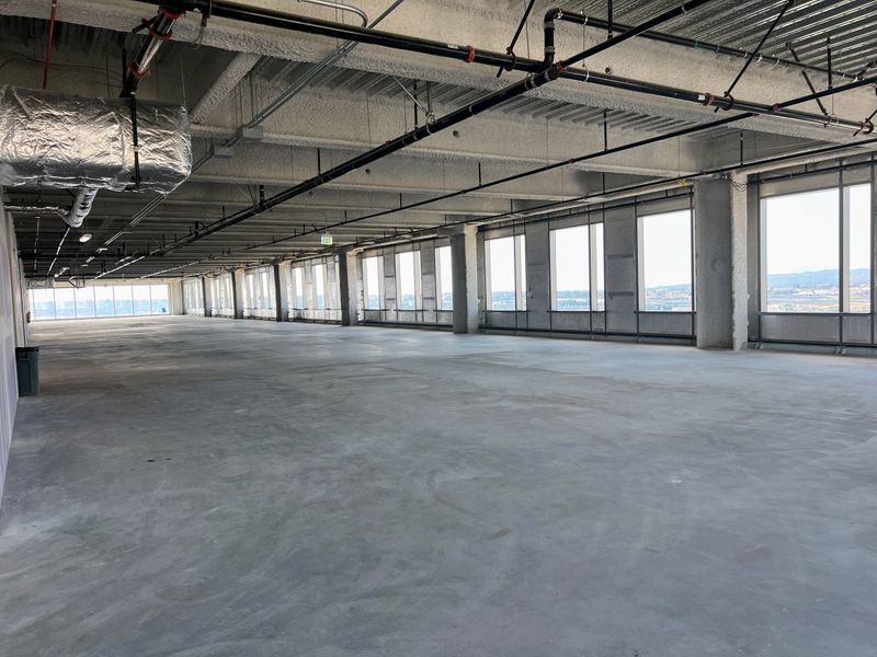 Views of large empty office space in shell condition with exposed beams and concrete