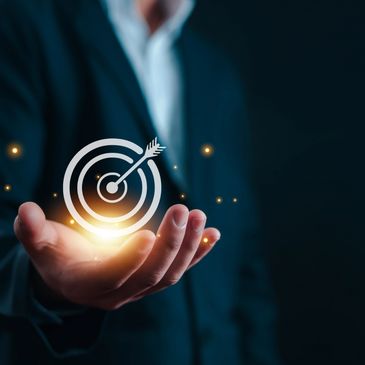 Businessman holding a glowing target symbol representing goal achievement.