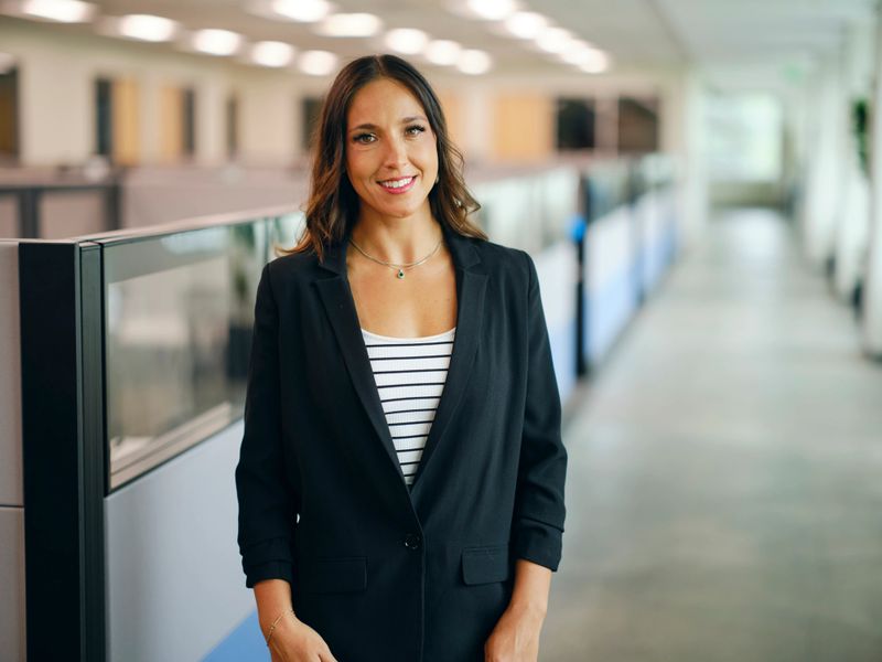 A happy woman standing in a company office.