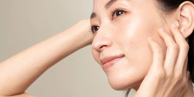 Close-up of a woman with clear, glowing skin and a gentle smile.