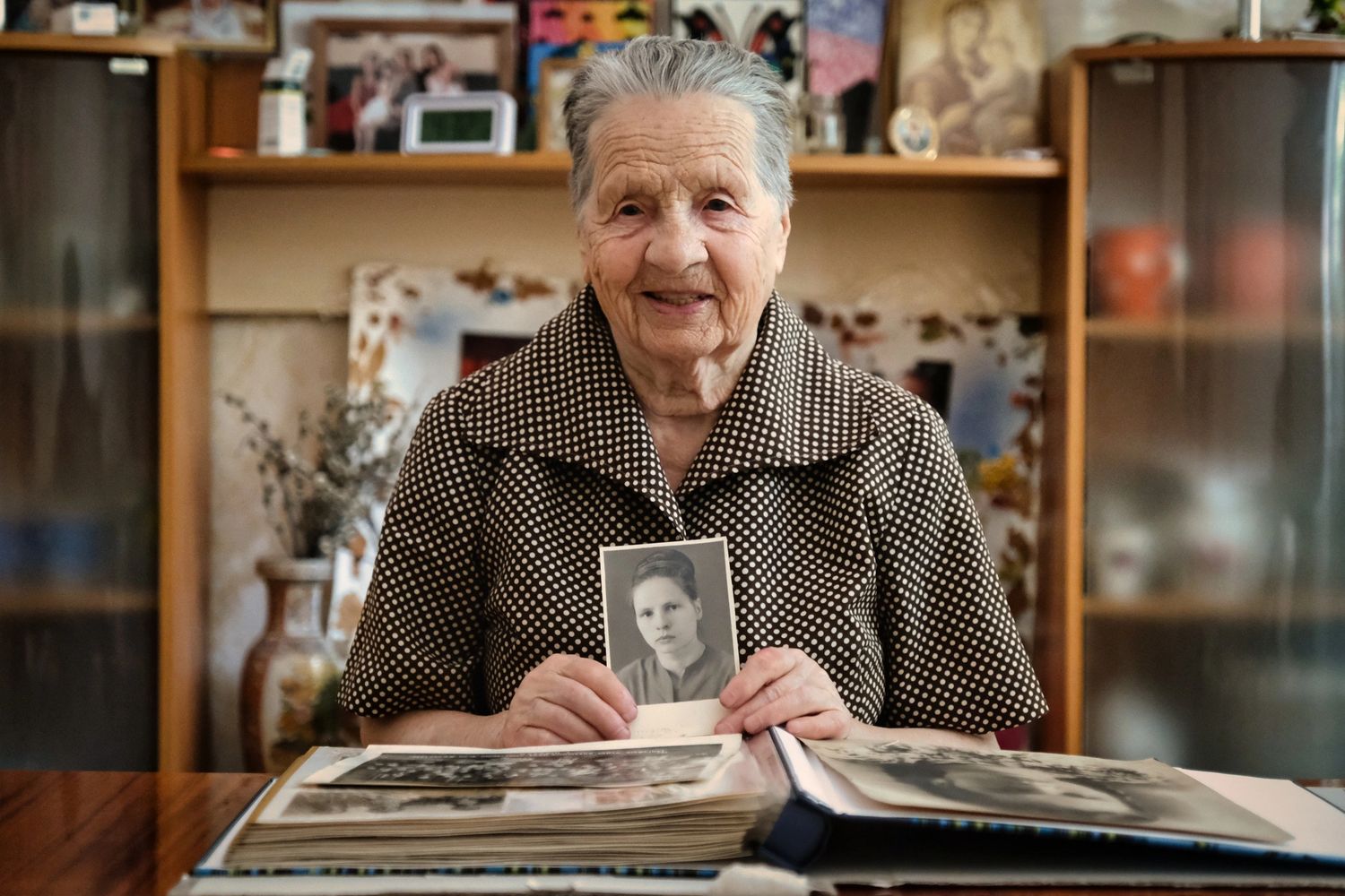 Stack of books next to pencils in a holder and a camera.