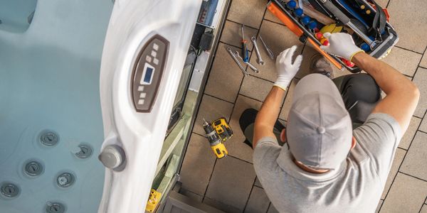 Technician preparing tools to repair a hot tub outdoors.