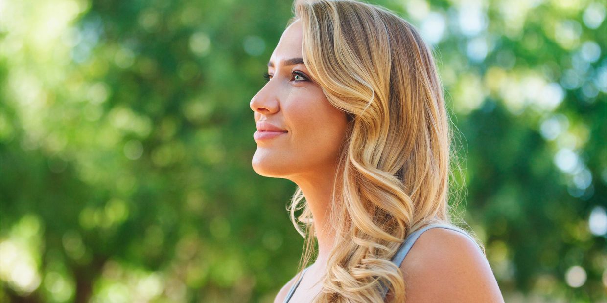 Long wavy blonde hair with dimensional balayage highlights and a sun-kissed finish.