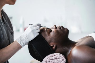 Man receiving a facial treatment.