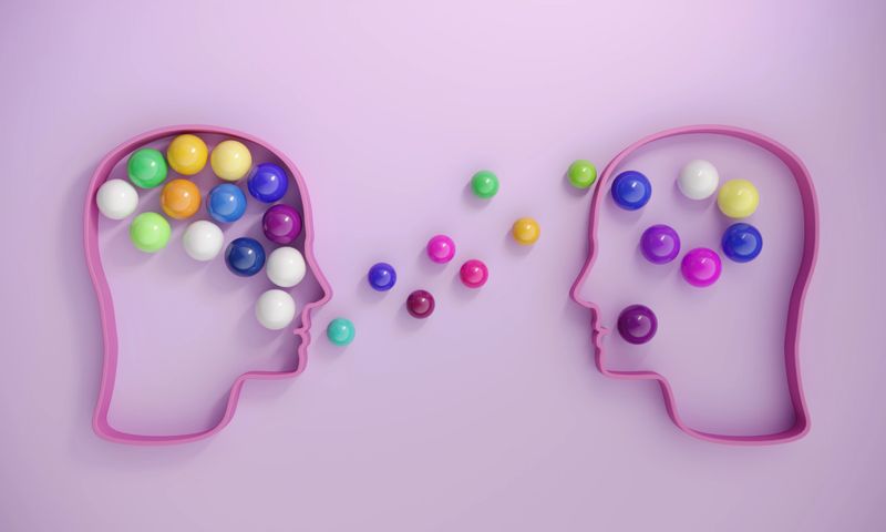 Human heads includes lots of multi colored spheres, symbolizing communication concepts. (3d render)