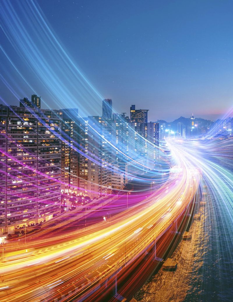 Nighttime view of Hong Kong with a highway illuminated by long exposure light trails.