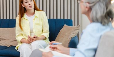 A woman talking to a therapist in a counseling session.